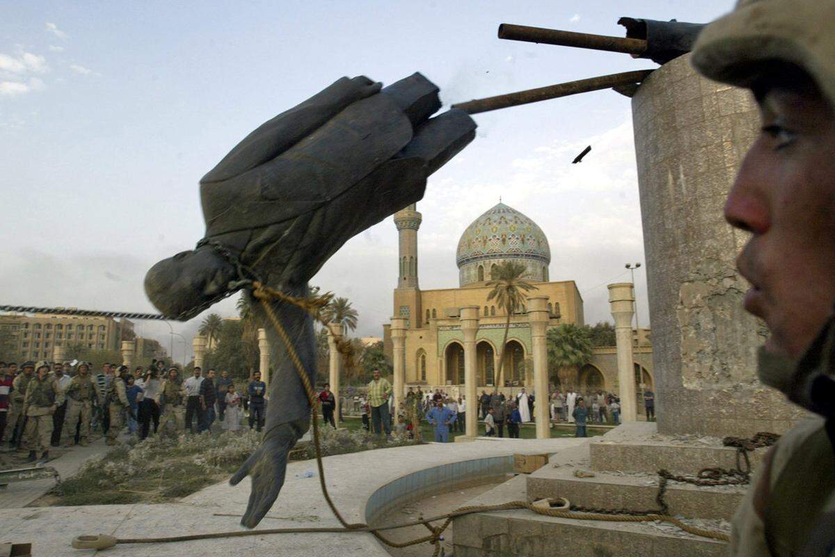 Am 9. April 2003 fällt die Saddam-Hussein-Statue im Zentrum von Bagdad. Ein US-Soldat beobachtet das Szenario.