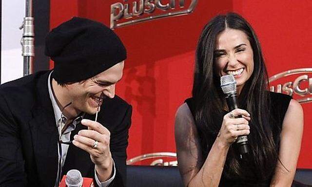 US actors Kutcher and Moore react during an interview in Pasching