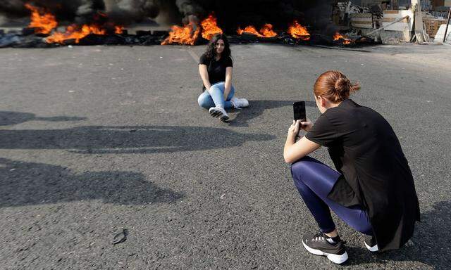 Erinnerungsfoto vor brennenden Autoreifen. Im Libanon protestieren vor allem junge Frauen und Männer gegen die prekäre Lage.