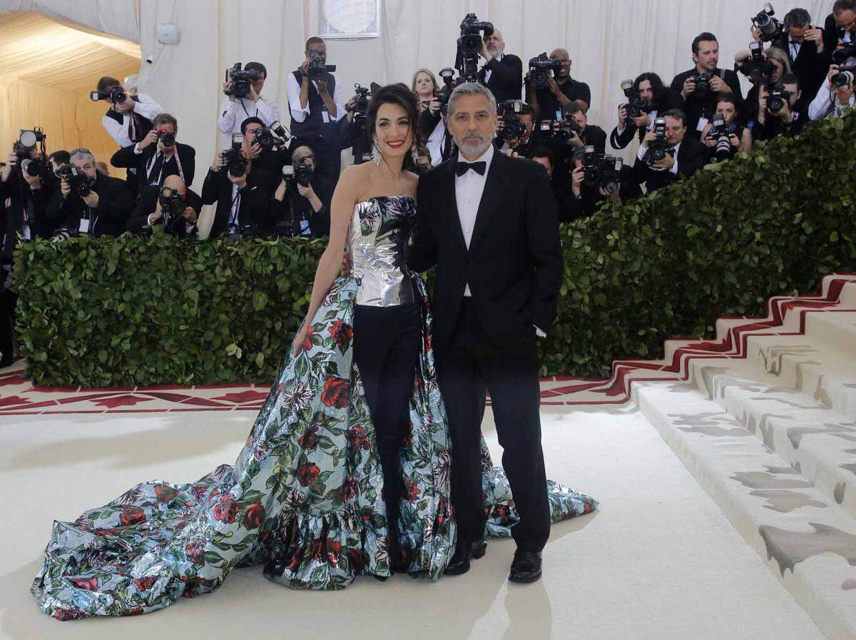 Die meterlange Schleppe ihres glitzernden Outfits machte auch Co-Gastgeberin Amal Clooney zu schaffen, die das Event gemeinsam mit "Vogue"-Herausgeberin Anna Wintour ausrichtete. Ehemann George Clooney schien wenig Mitleid zu haben: Auf die Frage hin, wo die Zwillinge des Paares heute Abend seien witzelte er, die Kleinen steckten unter der Schleppe.