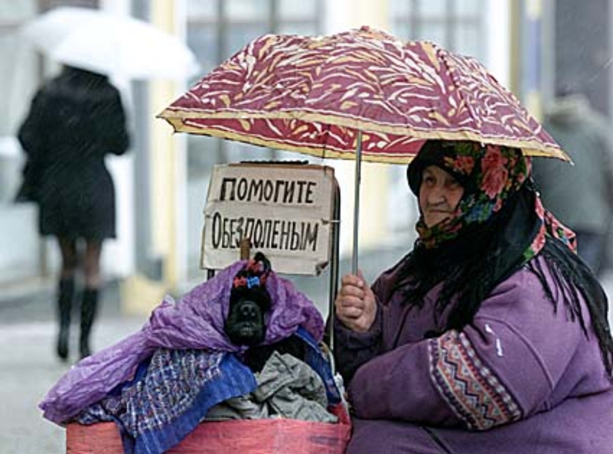 Eine ältere Frau schützt sich und ihren Hund in Kiew auf gleiche Weise vor der Kälte.