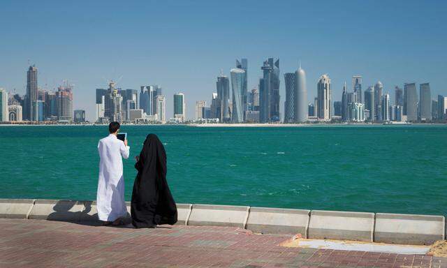 IMAGO Creative: FIFA WM 2022, Katar-Kultur  Man and woman looking at skyscrapers over water, Doha, Qatar, 04.07.2013, Co