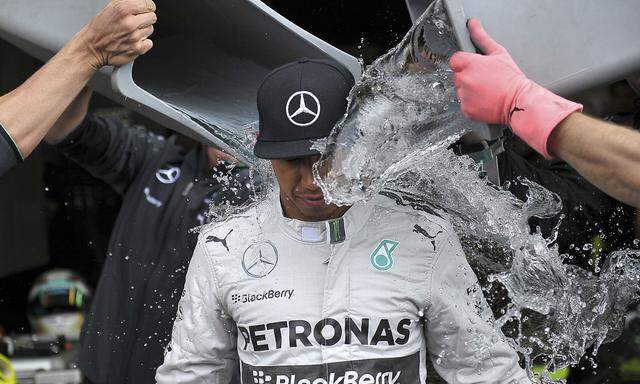 McLaren Mercedes team members dump buckets of ice water onto Formula One driver Lewis Hamilton of Britain as he takes part in the ´Ice Bucket Challenge´ after the first practice session at the Belgian F1 Grand Prix in Spa-Francorchamps
