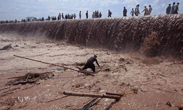 Retten, was zu retten ist: Ein Pakistaner versucht, die Reste seines Geschäfts vor den Fluten zu bewahren. 