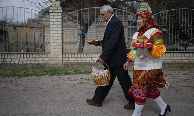 Members of the Nekrasov Cossack community, who are descended from the Don Cossacks and are Orthodox Old Believers, carry Easter eggs and traditional bread during Easter Sunday in the settlement of Novokumsk