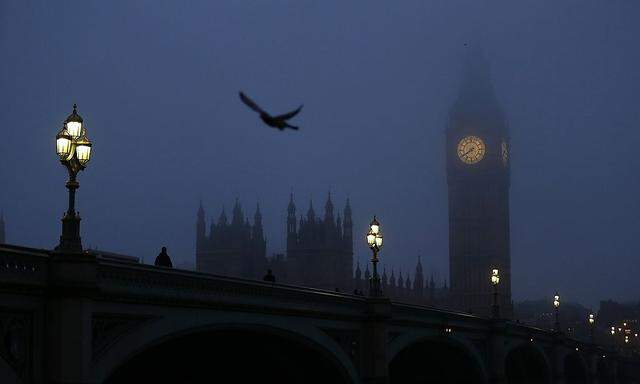 The Big Ben clock tower and the Houses of Parliament are seen in pre-dawn light on a foggy morning in central London