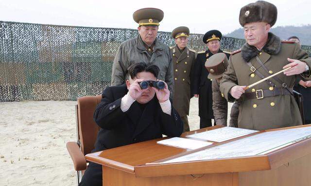 Handout file photo of North Korean leader Kim Jong Un looking through a pair of binoculars as he guides the multiple-rocket launching drill of women´s sub-units under KPA Unit 851
