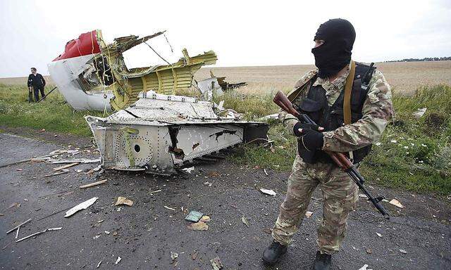 A pro-Russian separatist stands at the crash site of Malaysia Airlines flight MH17, near the settlement of Grabovo in the Donetsk region