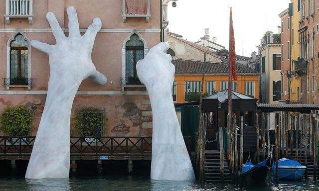 Italian artist Lorenzo Quinn's installation called ' Support' is seen on Ca' Sagredo palace during the 57th La Biennale of Venice, in Venice