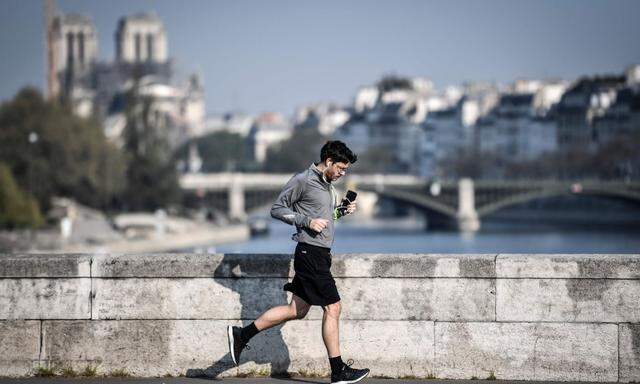 Ein Jogger vor dem Hintergrund der Kathedrale Notre Dame in Paris am 10. April, zwei Tage nach der Verschärfung der Jogging-Regeln.
