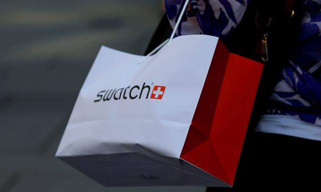 FILE PHOTO: A women carries a shopping bag of Swiss watchmaker Swatch in Vienna