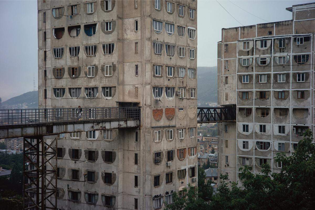 Wohnhaus in den Hügeln von Tiflis, Georgien. Es wurde von O. Kalandarishvili und G. Potskhishvili entworfen und 1976 gebaut. Die drei 16 Stockwerke hohen Türme sind durch einen Gang miteinander verbunden, der direkt auf einen Hügel führt.