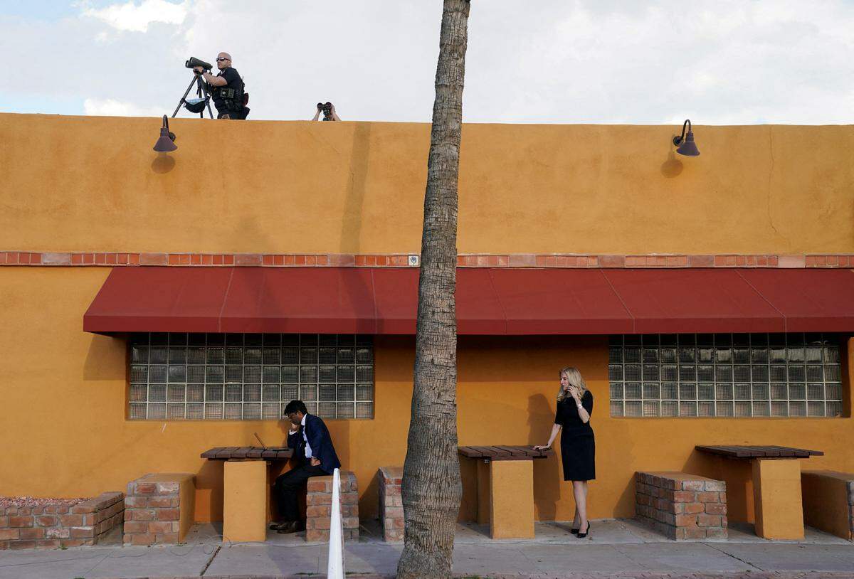 19. März. So sieht es außerhalb eines mexikanischen Restaurants im US-Bundesstaat Arizona aus, wenn im Inneren der US-Präsident auf Wahlkampftour ist: Redenschreiber Vinay Reddy am Laptop, Wirtschaftsberaterin Lael Brainard am Telefon und der Secret Service am Dach.     