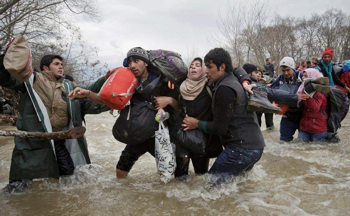 Vadim Ghirda gab seinem Foto den Titel "Migrant Crossing": es zeigt eine Frau, die von zwei Männern gestützt wird, als sie einen Fluss durchwaten, um nach Mazedonien zu gelangen. Sie gehören zu einer Gruppe von Flüchtlingen, die ein Lager an der mazedonisch-griechischen Grenze verlassen haben. 