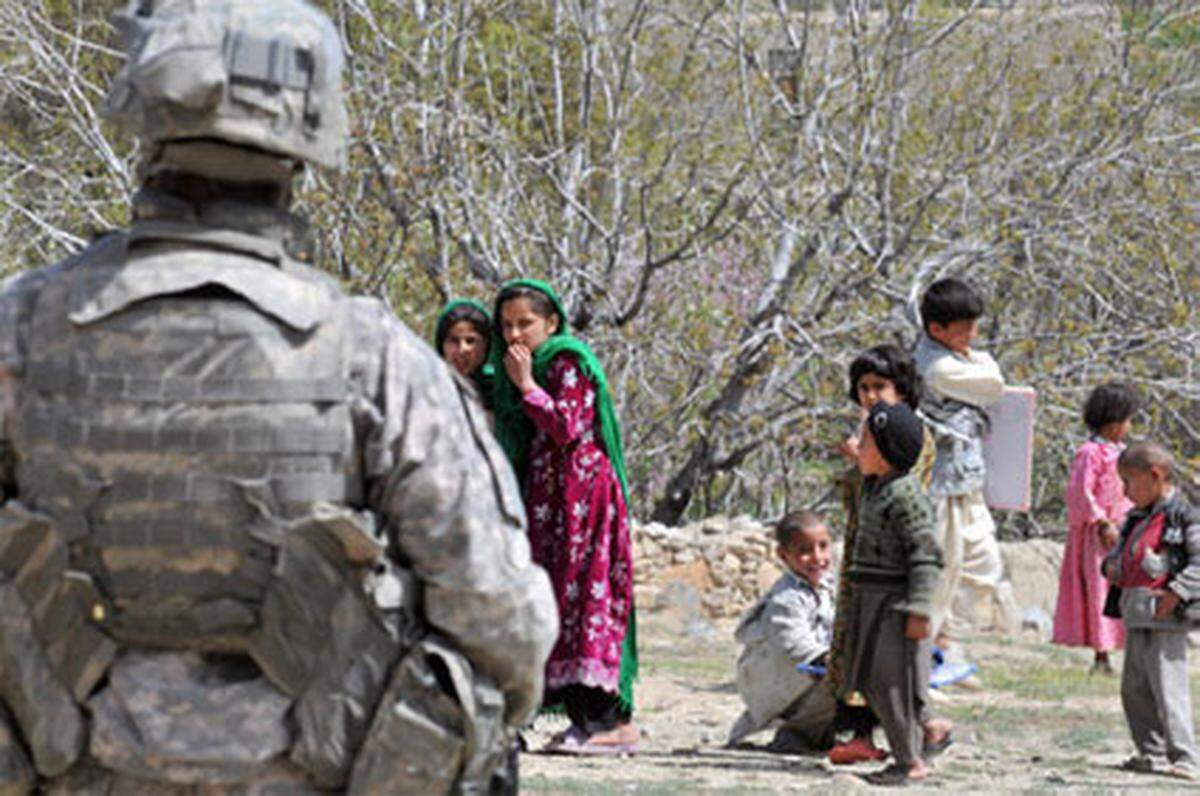 Ein US-Soldat sichert die Verteilung von Hilfsgütern in Sultankhel, Provinz Kapisa. Die Mädchen halten sich im Hintergrund