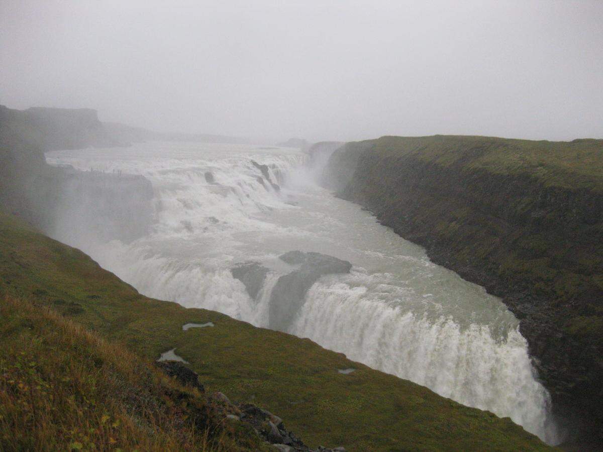 Der Gullfoss ist der berühmteste Wasserfall Islands, von der Hauptstadt Reykjavík leicht zu erreichen, meist in einer kleinen Runde, die auch den berühmtesten Geysir des Landes (“Strokkur”) einschließt. Die Hvítá, ein Fluss, der hier über zwei Stufen 32 Meter nach unten stürzt (zunächst 12 Meter, dann 21 Meter) produziert einen tollen Sprühregenvorhang. 140 Kubikmeter Wasser pro Sekunde im Sommer, 80 Kubikmeter im Winter stürzen in die Tiefe. Die Hvítá kommt aus dem 40 Kilometer höher gelegenen Langjökull und fällt in einen engen Canyon.