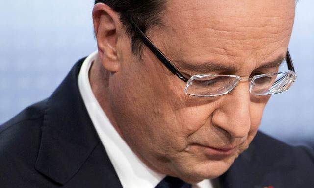 France's President Hollande reads his notes before appearing on France 2 television prime time news broadcast for an interview at their studios in Paris 