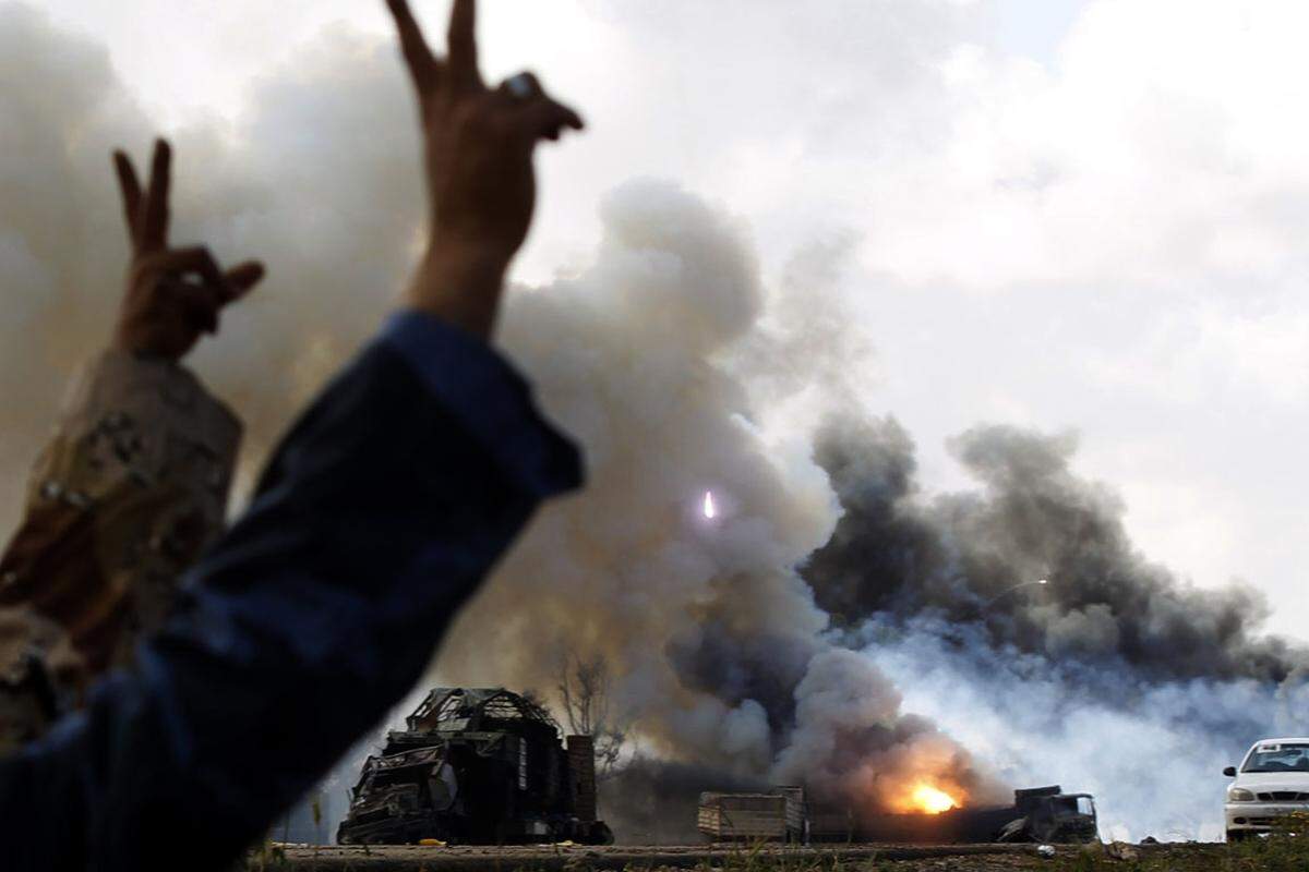 Brennende Fahrzeuge der Streitkräfte von Muammar al-Gaddfi entlang einer Straße zwischen Bengasi und Ajdabiyah.