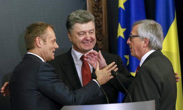 European Council President Tusk, European Commission President Juncker and Ukrainian President Poroshenko react during a news conference after their meeting in Kiev