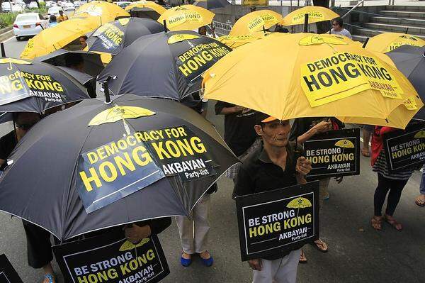 Der Regenschirm eignet sich auch gut, international Solidarität zu zeigen: Hier etwa demonstrieren philippinische Aktivisten vor dem chinesischen Konsulat in Manila.