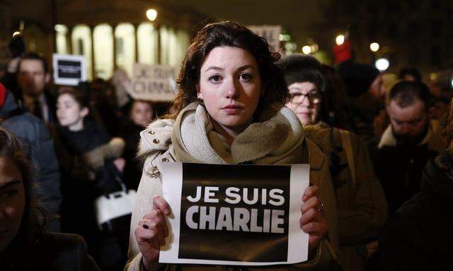 Woman holds a placard during a vigil to pay tribute to the victims of a shooting by gunmen at the offices of weekly satirical magazine Charlie Hebdo in Paris, at Trafalgar Square in London