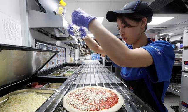 A staff member prepares a pizza at a Domino´s Pizza restaurant in Moscow