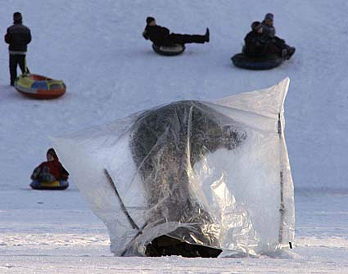 Man sollte meinen, dass die Russen an Väterchen Frost gewohnt sind, aber bei minus 13 Grad in Sankt Petersburg geht dieser Eisfischer kein Risiko ein.