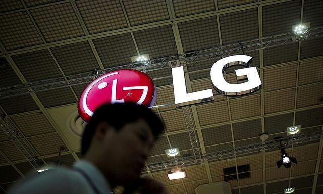 FILE PHOTO: A man talking on his phone walks past the logo of LG Electronics during Korea Electronics Show 2016 in Seoul