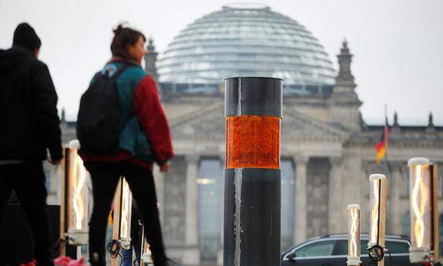 People walk past a temporary memorial, a column dedicated to the victims of the Holocaust, set up by activists of the 'Zentrum fuer politische Schoenheit' (Center for Political Beauty) in Berlin
