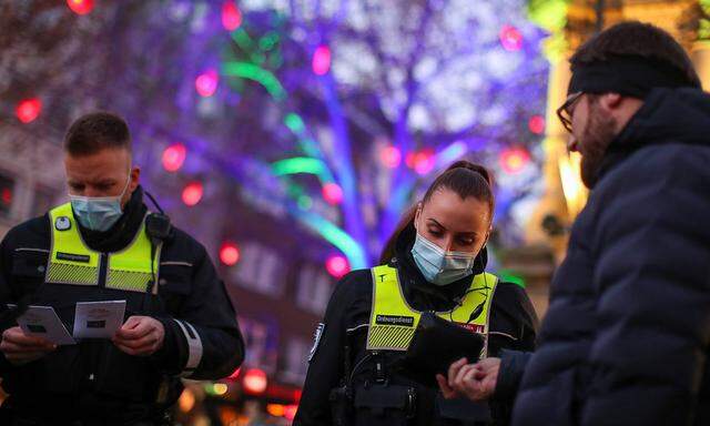 Public order staff controls the '2G' rule on a Christmas market in Cologne
