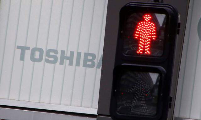 Toshiba's logo is seen behind a traffic sign at an electronic shop in Tokyo
