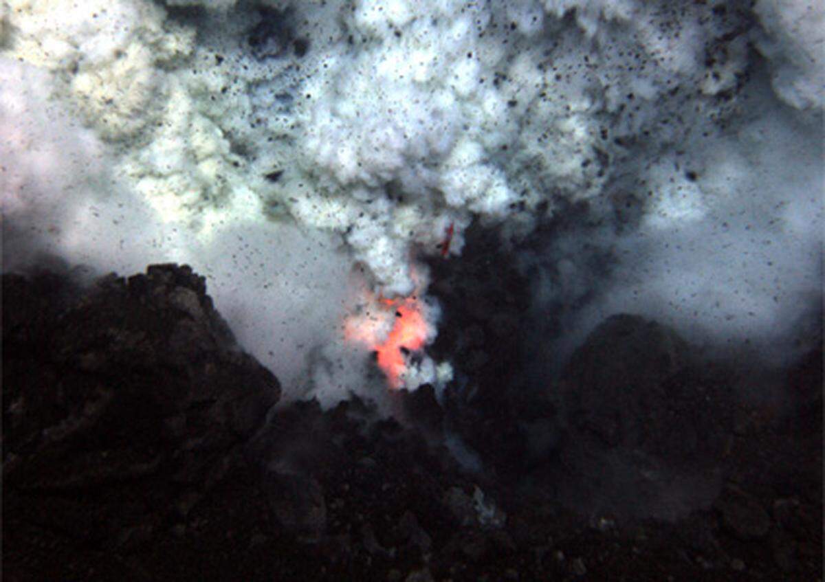 Explosionen schleudern Asche und Felsen ins Wasser. Da der enorme Wasserdruck in dieser Tiefe die Wucht der Eruptionen eindämmt, konnte ein Beobachtungsroboter näher heran als an vergleichbare Vulkane in geringeren Tiefen oder an der Oberfläche.