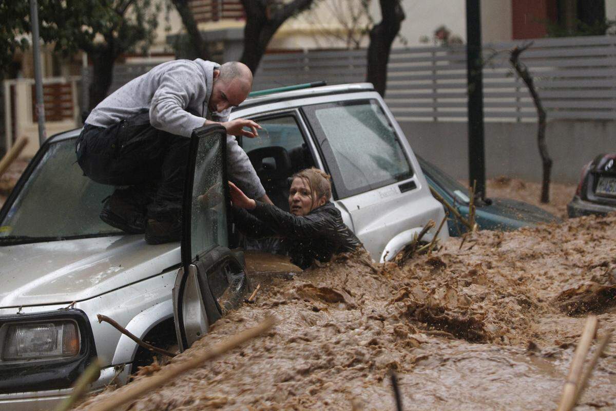 Eine Frau versucht in den Fluten der heftigen Regenfälle in Chalandri bei Athen aus ihrem Auto zu entkommen. Aufnahme vom 22. Februar 2013.