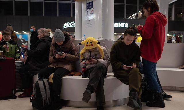March 8, 2022, Warsaw, Warsaw, Poland: Ukrainian refugees use their smartphones as they wait at Warsaw Central train st
