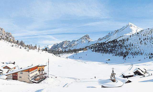 Wie eine Schüssel liegt das Almgebiet von Klein-Fanes und Groß-Fanes inmitten der Dolomiten. Links: die Lavarella-Hütte, ganz im Hintergrund das Rifugio Fanes. Unterm Schnee liegt der Gebirgssee Le Vert. 