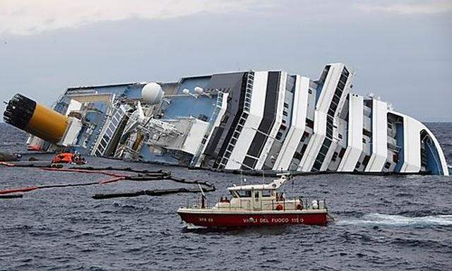 Fire brigade boat goes past the capsized cruise liner Costa Concordia off the west coast of Italy at 