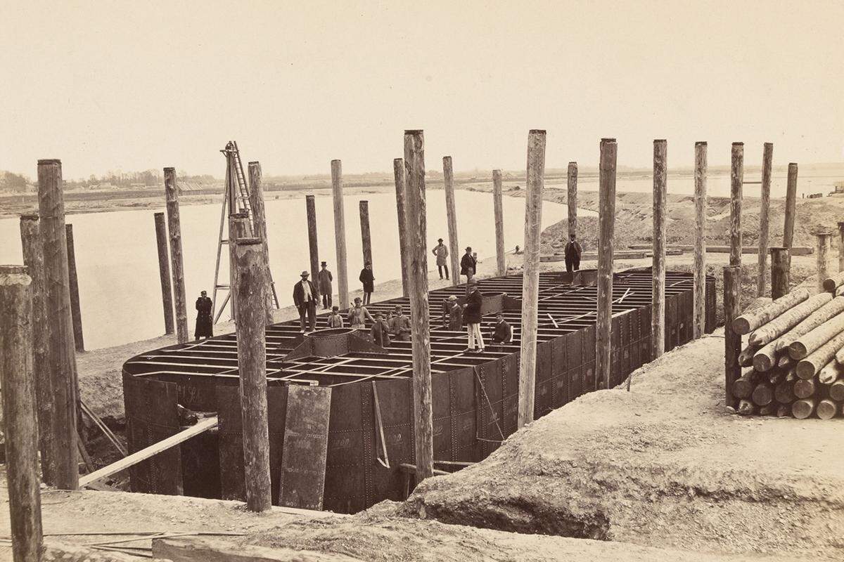 Ausgehend vom Wirtschaftsboom in den späten 1860er-Jahren wurden zahlreiche Bauprojekte in Angriff genommen - darunter die repräsentativen Bahnhöfe, Brücken über Donau und Wien-Fluss, das Rathaus als Symbol für die wachsende Bedeutung der Kommunalpolitik gegenüber der höfischen Obrigkeit und freilich die Ringstraße mit ihren "Logenplätzen der Superreichen".Bild: Bau der Reichsbrücke, 1873