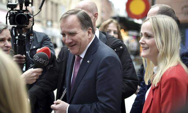 Swedish Prime Minister Stefan Lofven (C) is surrounded by journalists as he walks from the government headquearters to t