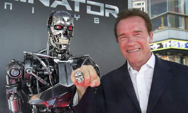 Schwarzenegger poses by a Terminator replica at the premiere of 'Terminator Genisys' in Hollywood