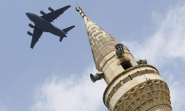 File photo of a U.S. Air Force Boeing C-17A Globemaster III large transport aircraft flies over a minaret after taking off from Incirlik air base in Adana