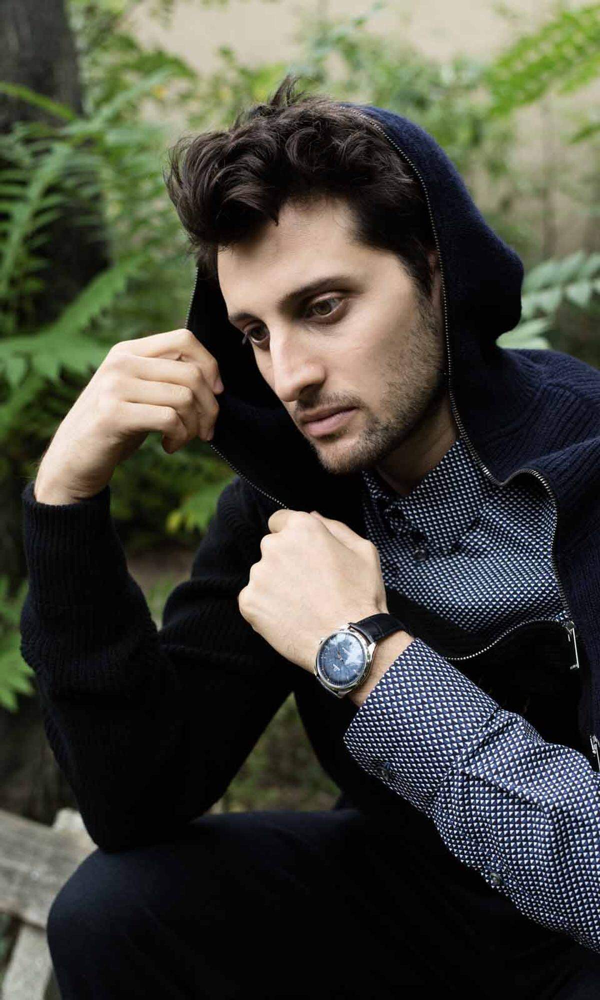 Hemd und Hose von Giorgio Armani, Pullover von Fendi. Die Uhr ist eine „De Ville Trésor" mit Edelstahlgehäuse, blauem Zifferblatt und schwarzem Lederband von Omega.