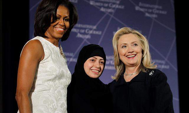 FILE PHOTO: U.S. Secretary of State Hillary Clinton and First lady Michelle Obama congratulate Samar Badawi of Saudi Arabia in Washington