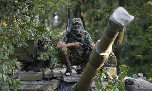 Pro-Russian separatist from the Vostok battalion poses for a picture atop a T-64 tank in Donetsk, eastern Ukraine