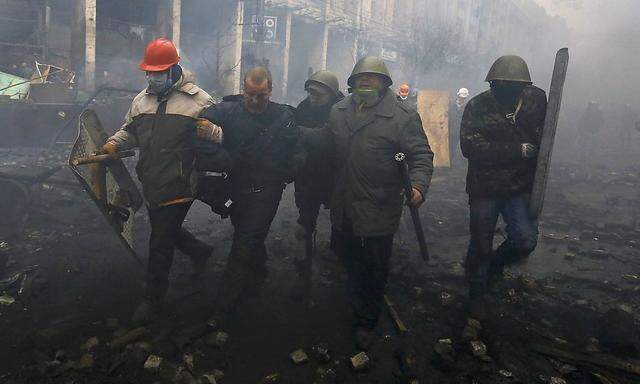 Anti-government protesters detain a policeman during clashes in the Independence Square in Kiev