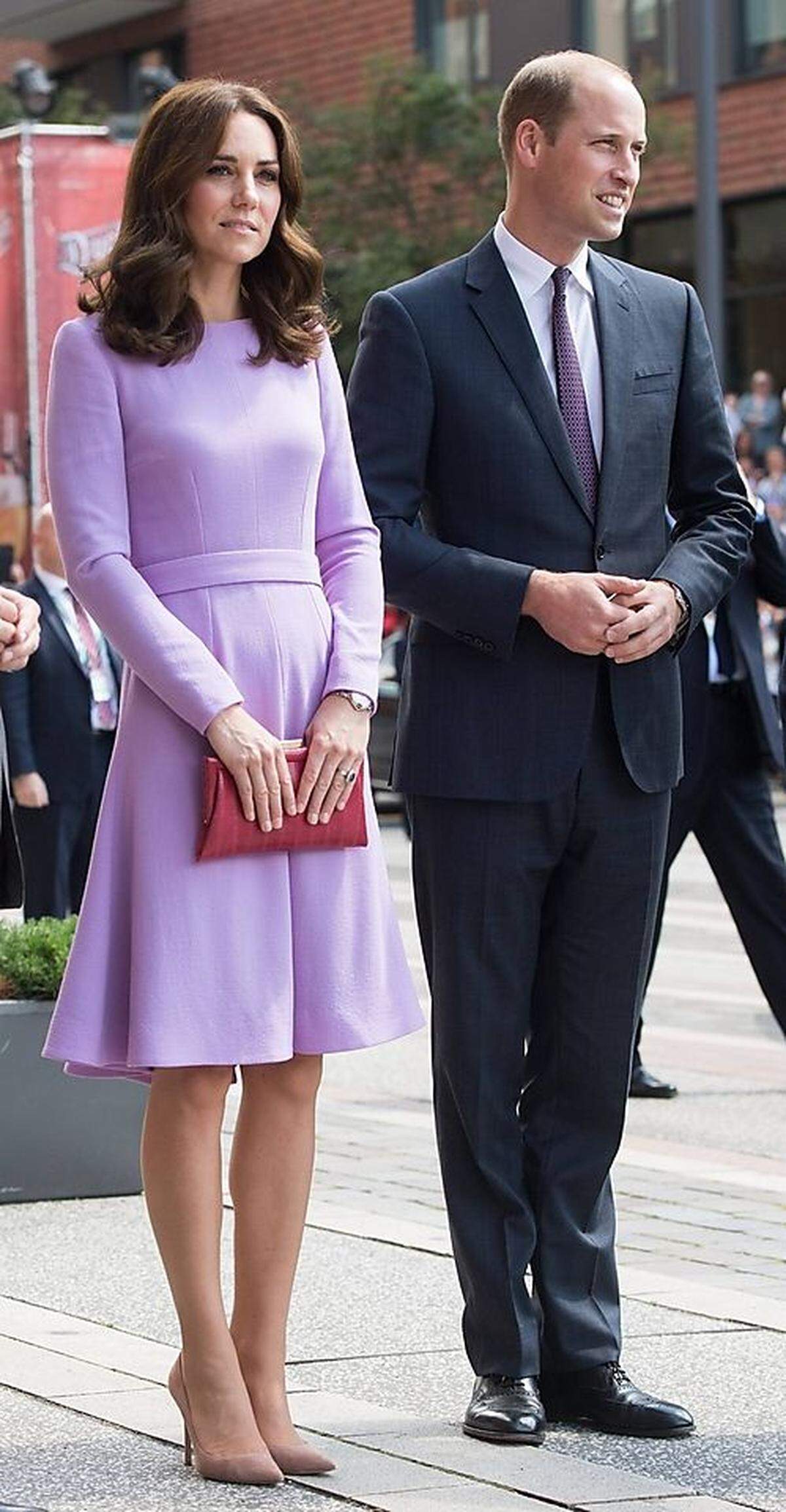 Nanu? Was ist mit Kates Vorliebe für Navy, Creme und Bordeauxrot passiert? Eine lavendelblaues Kleid von Emilia Wickstead trifft bei einem Auftritt in Hamburg auf eine rote Schlangenlederclutch von Anya Hindmarch und hellrosafarbene Pumps von Gianvito Rossi: eine mutige Wahl, die absolut aufgeht, und untypisch ist für die Herzogin von Cambridge.