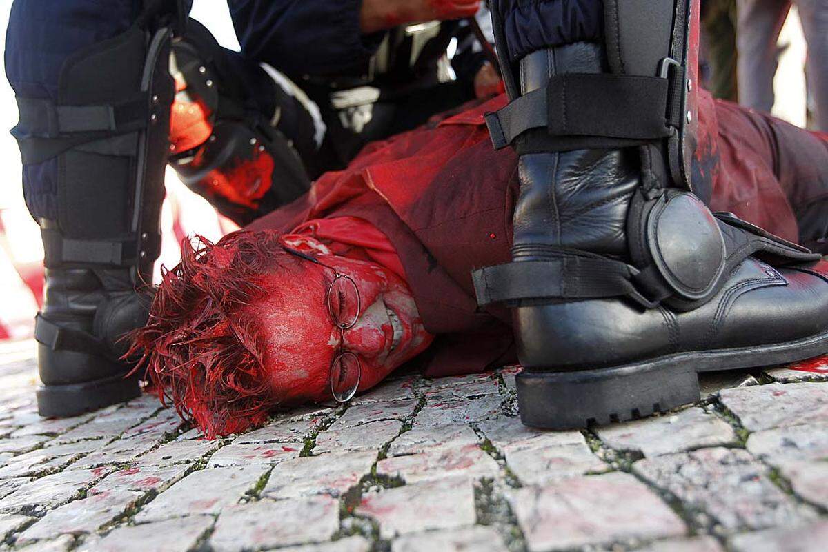 Ein Demonstrant gegen den Nato-Gipfel in Lissabon wird von der Polizei zu Boden gerungen.