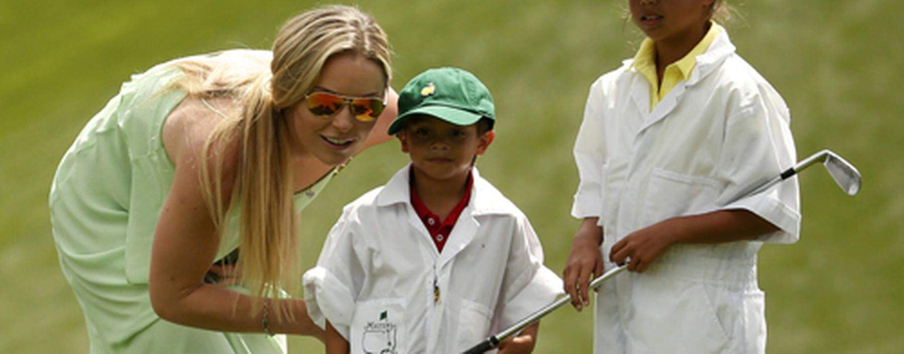 U.S. golfer Woods´ girlfriend Vonn speaks with Woods´ son Charlie and daughter Sam during the par 3 event held ahead of the 2015 Masters at Augusta National Golf Course in Augusta