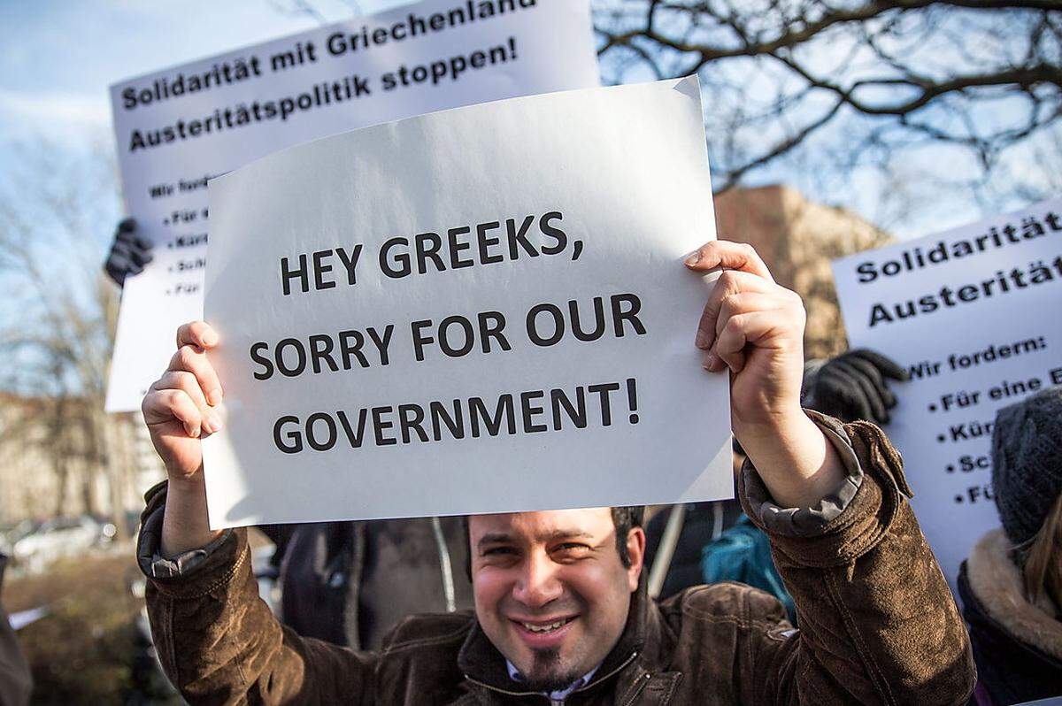 Von Anfang an forderte Varoufakis keine neuen Rettungspakete für Griechenland sondern eine tiefe und endgültige Lösung. Gleichzeitig versprach er der Eurozone einen ausgeglichen Haushalt – und meinte: Die Griechen seien glücklicher gewesen, als sie keine Kreditkarten gehabt und ihr Erspartes für die Bildung ihrer Kinder ausgegeben hätten. Viele Konservative fürchteten nach seinem Amtsantritt, dass Varoufakis und Regierungschef Alexis Tsipras von den Linken die Uhren in Griechenland um 50 Jahre zurückdrehen könnten.Im Bild: Deutsche Syriza-Fans in Frankfurt