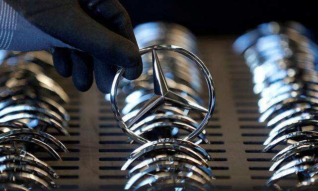 FILE PHOTO: An employee of German car manufacturer Mercedes Benz prepares the company's logo prior to its installation at the A-class production line at the Daimler factory in Rastatt