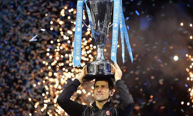 Djokovic of Serbia raises the trophy after defeating Nadal of Spain in their men's final singles tennis match at the ATP World Tour Finals in London